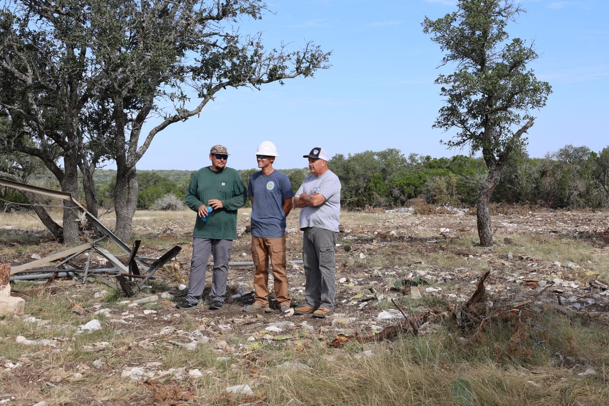 Three Triangle J crew members standing at a cleared well site in North Texas