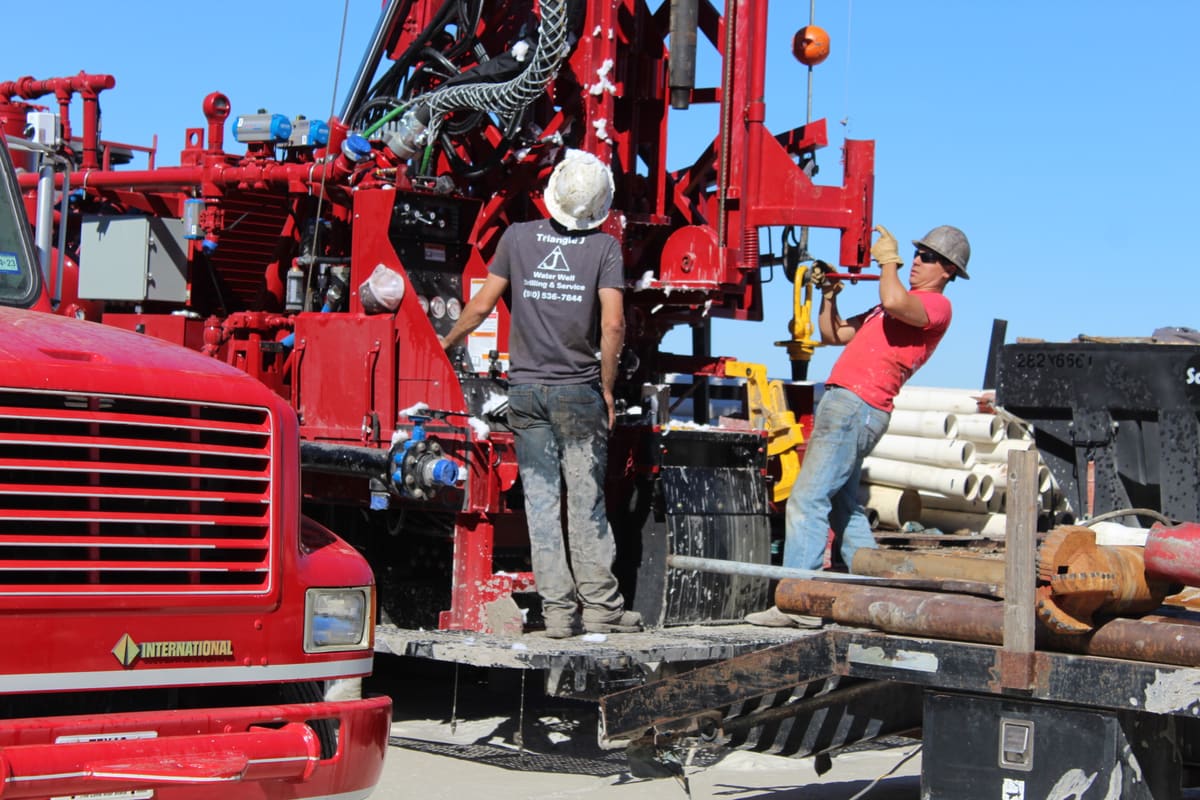 Triangle J crew setting well casing on the rig deck with new pipe staged beside them